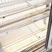 Metal wire shelves inside a refrigerator with a white interior.