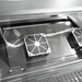 Two fans mounted on a metallic surface with a reflective background