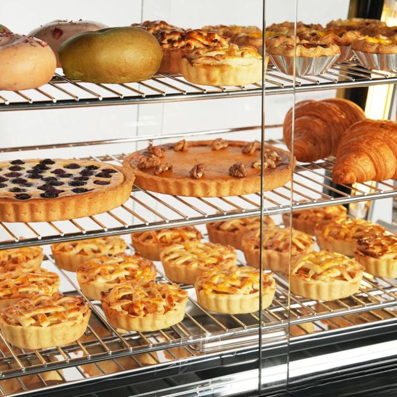 Display case with various baked goods including pies and pastries.