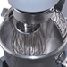 Close-up of a stand mixer with a whisk attachment inside a bowl.
