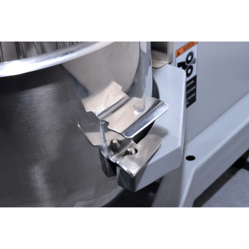 Close-up of a metal mixing bowl with a dough hook attachment on a kitchen appliance.