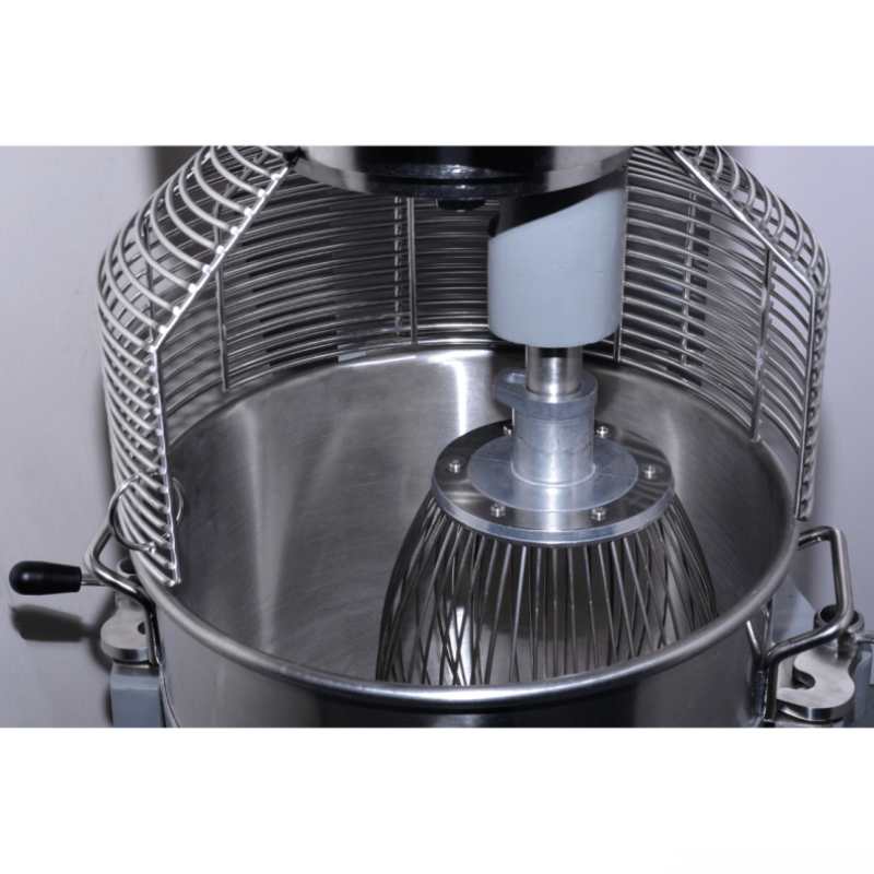 Close-up of a metal mixing bowl with a whisk attachment on a white background